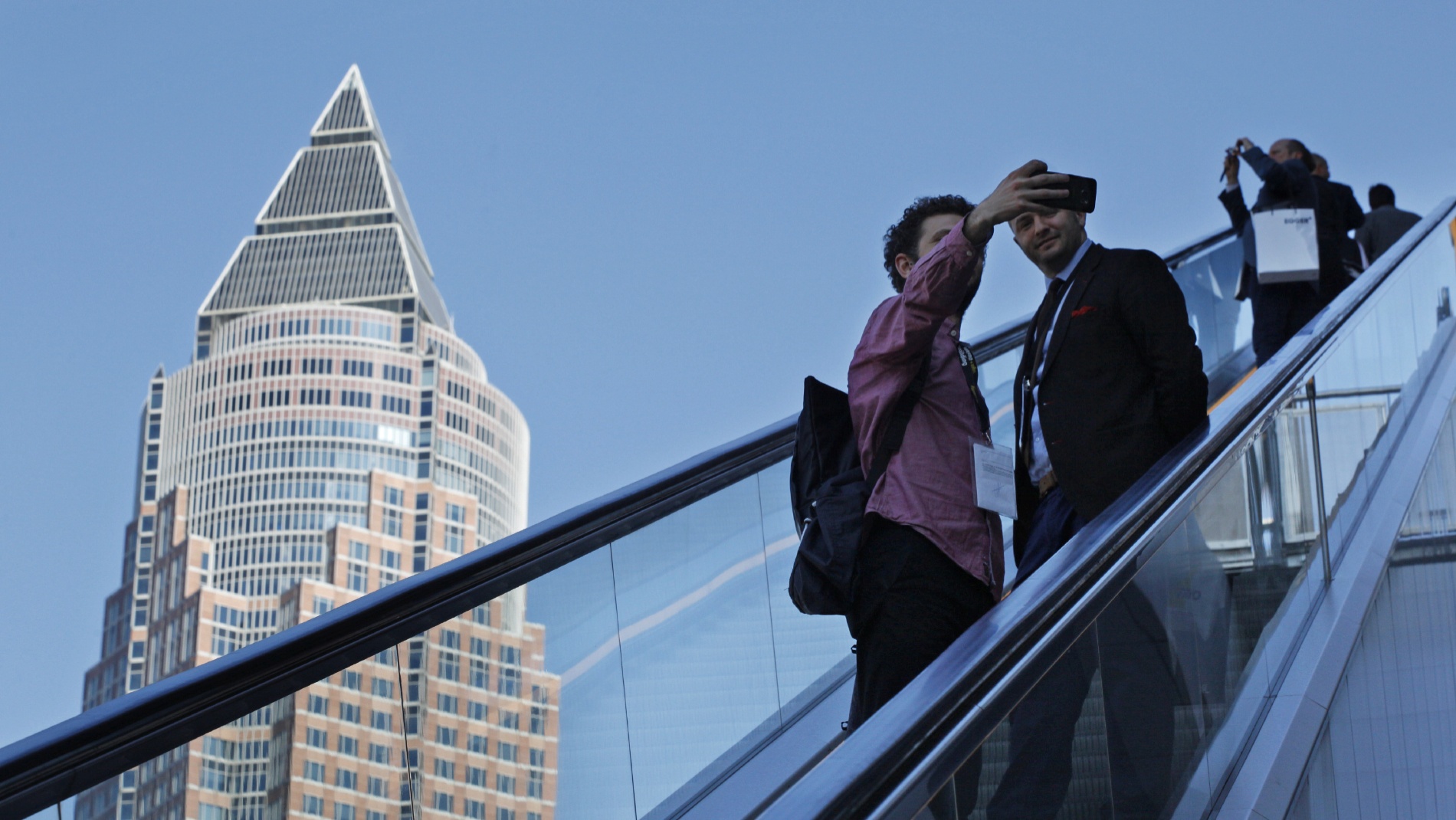 Personen machen ein Selfie vor dem Messeturm in Frankfurt